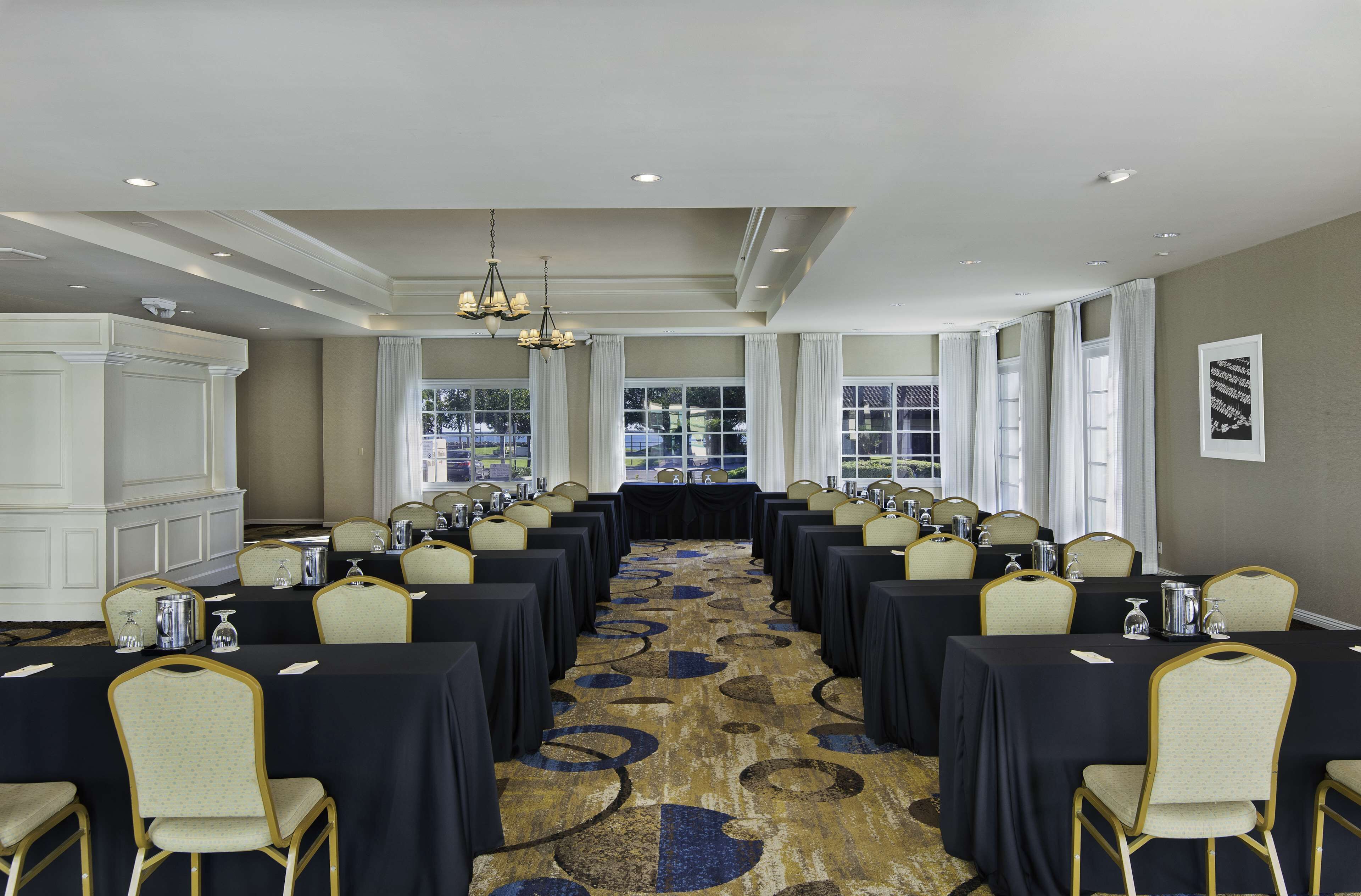 A conference room with long tables, chairs, and a chandelier.
