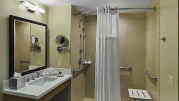 A modern bathroom with a sink, mirror, and shower.