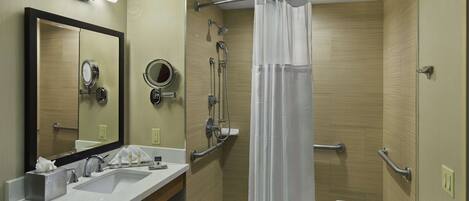 A modern bathroom with a sink, mirror, and shower.
