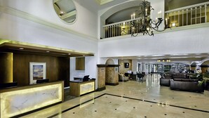 A spacious lobby with a reception desk, seating area, and a chandelier. - DoubleTree by Hilton San Pedro - Port of Los Angeles (San Pedro)