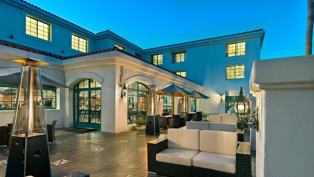 A spacious outdoor patio with seating areas, a central heating unit, and a staircase leading to an upper level. - DoubleTree by Hilton San Pedro - Port of Los Angeles (San Pedro)