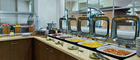 A buffet setup with multiple food stations, including a variety of dishes and utensils.