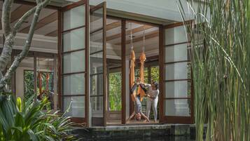 A room with large windows, a view of a water body, and indoor plants.