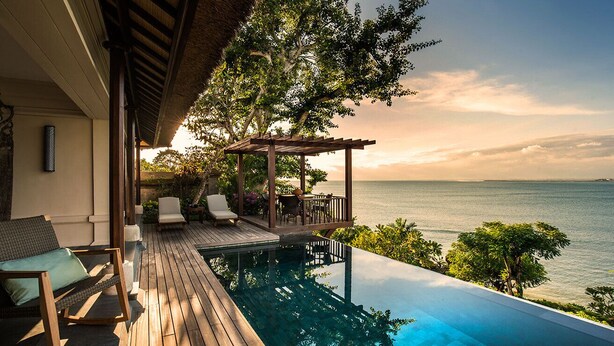 An infinity pool with a wooden deck, lounge chairs, and a pergola overlooking the sea. - Four Seasons Resort Bali at Jimbaran Bay (Jimbaran)
