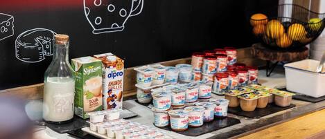 Una exposición de productos lácteos, con diferentes tipos de leche e ilustraciones de alimentos en una pizarra.