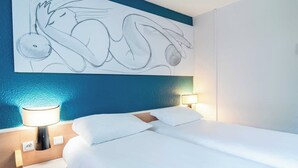 A hotel room with a bed, bedside lamps, a wall painting, and a blue accent wall. - B&B Hotel Limoges 3 (Limoges)