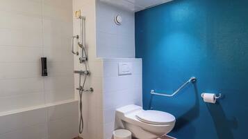 A bathroom with a bathtub, a toilet, and a shower.