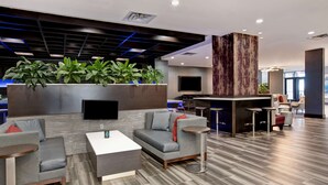 A modern lobby with a sofa, coffee table, and bar area. - Embassy Suites by Hilton Oklahoma City Northwest (Oklahoma City)
