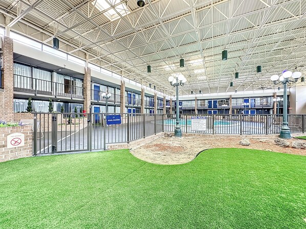 An indoor pool area with a closed pool sign, a no diving sign, and a pool rules sign.