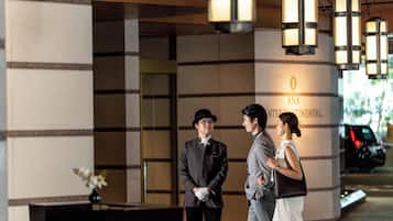 A hotel entrance with a modern design, featuring a reception area and a sign that reads "ANA INTERNATIONAL."