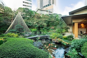 A serene garden with a koi pond, lush greenery, and a traditional rope bridge. - InterContinental ANA Tokyo by IHG (Tokyo)
