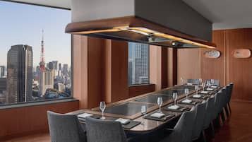 Un salón de conferencias con una larga mesa, sillas y vistas a la ciudad.