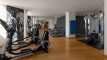 A modern gym with cardio equipment, weight machines, and a large exercise ball.