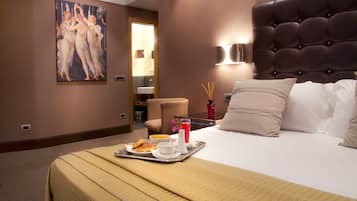 A hotel room with a large bed, a painting on the wall, a tray with breakfast items, and a bathroom visible through an open door.