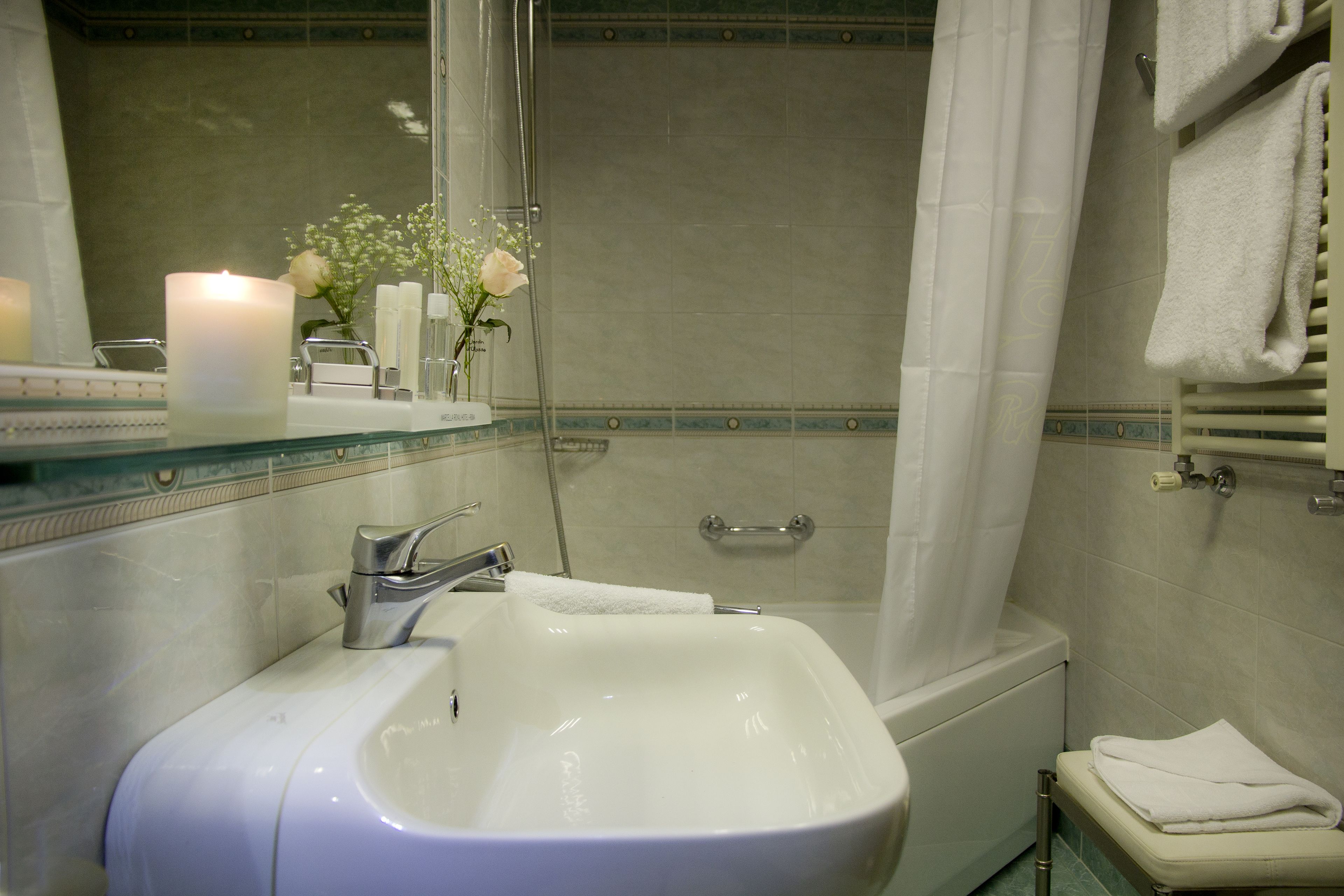 Une salle de bain avec un lavabo blanc, une douche en verre et une baignoire.