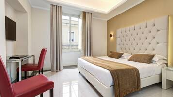 A hotel room with a bed, a desk, and a chair.