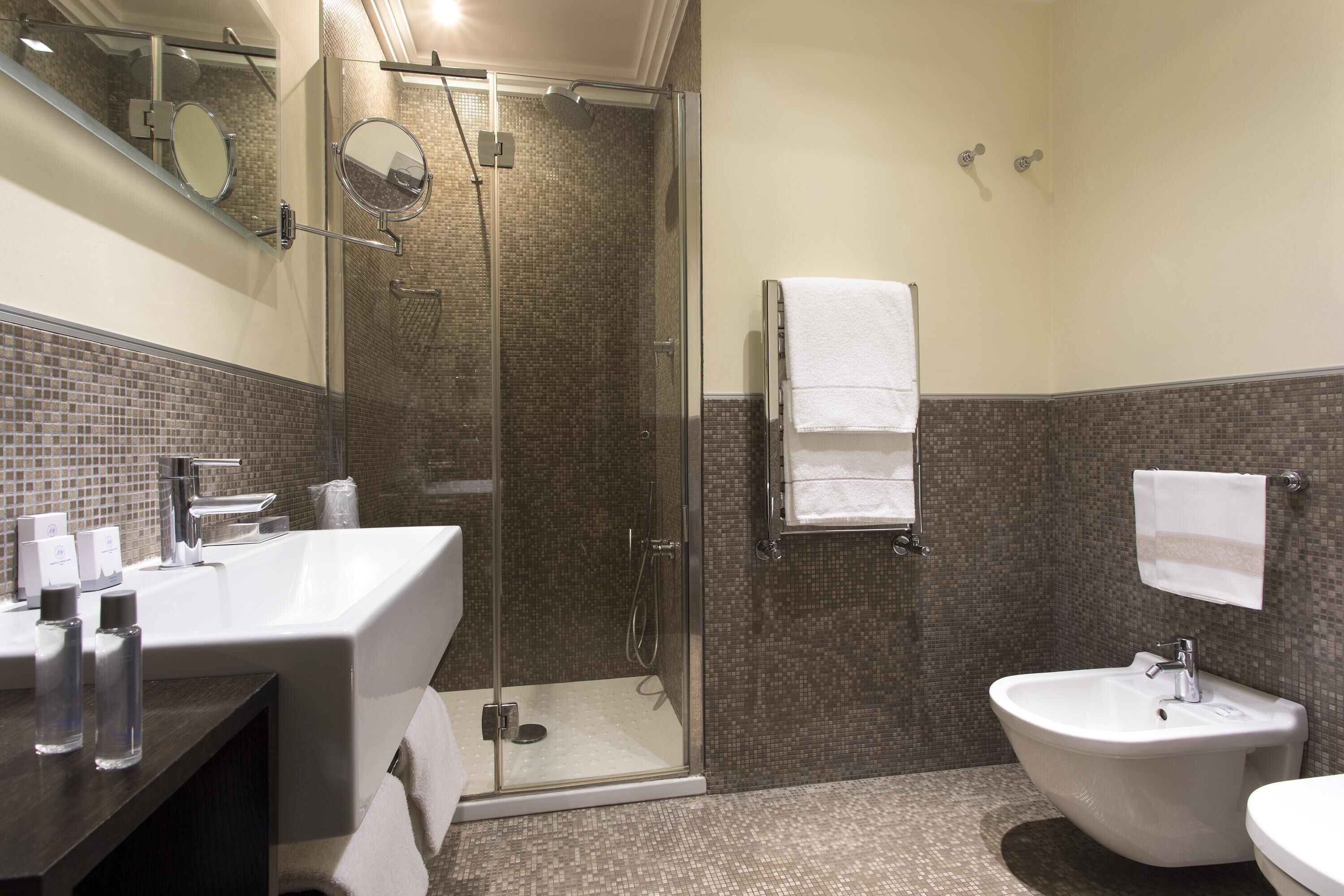 A modern bathroom with a glass-enclosed shower, a white sink, and a freestanding bathtub.