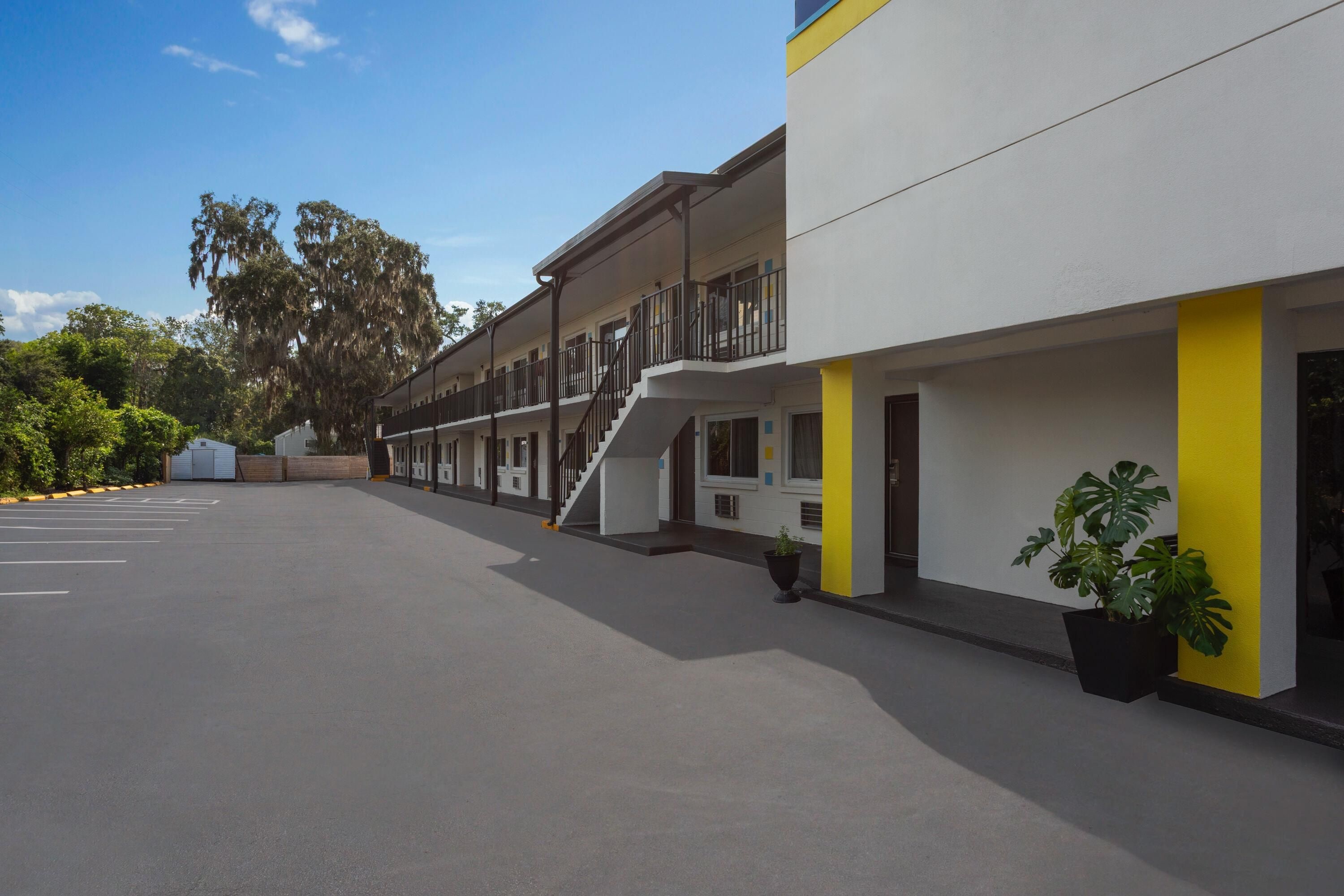 A multi-story hotel with a parking lot in front.