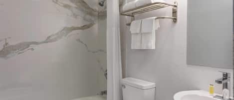 Un baño con pared de mármol, ducha, inodoro, lavabo y un perchero para toallas.