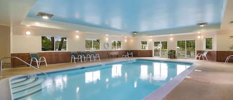 Una piscina techada, sillones reclinables de piscina