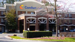 A Comfort Inn hotel with a brick facade, arched windows, and a landscaped entrance. - Clarion Pointe Durham Research Triangle Park (Durham)