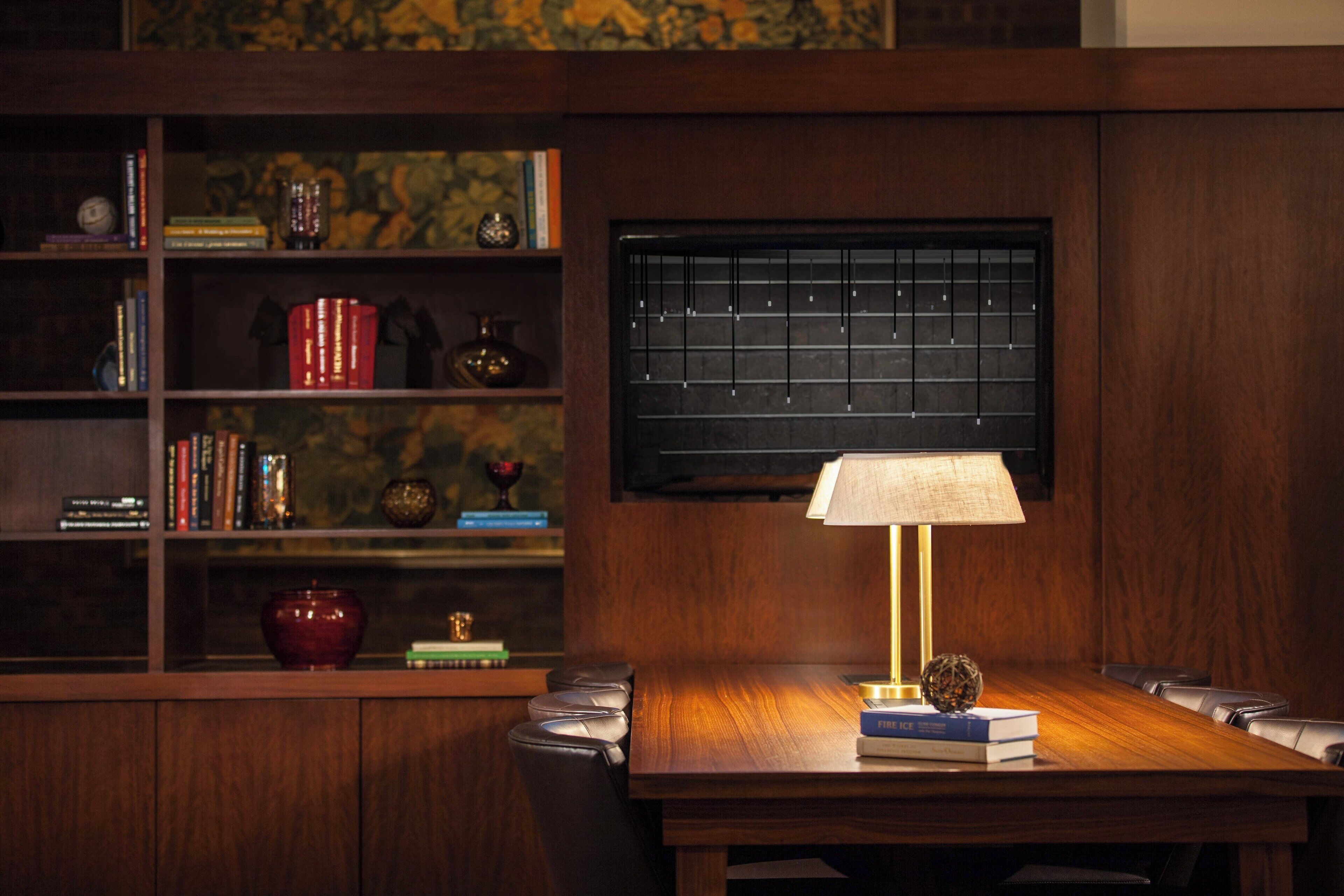 A wooden table with a lamp, books, and decorative items.