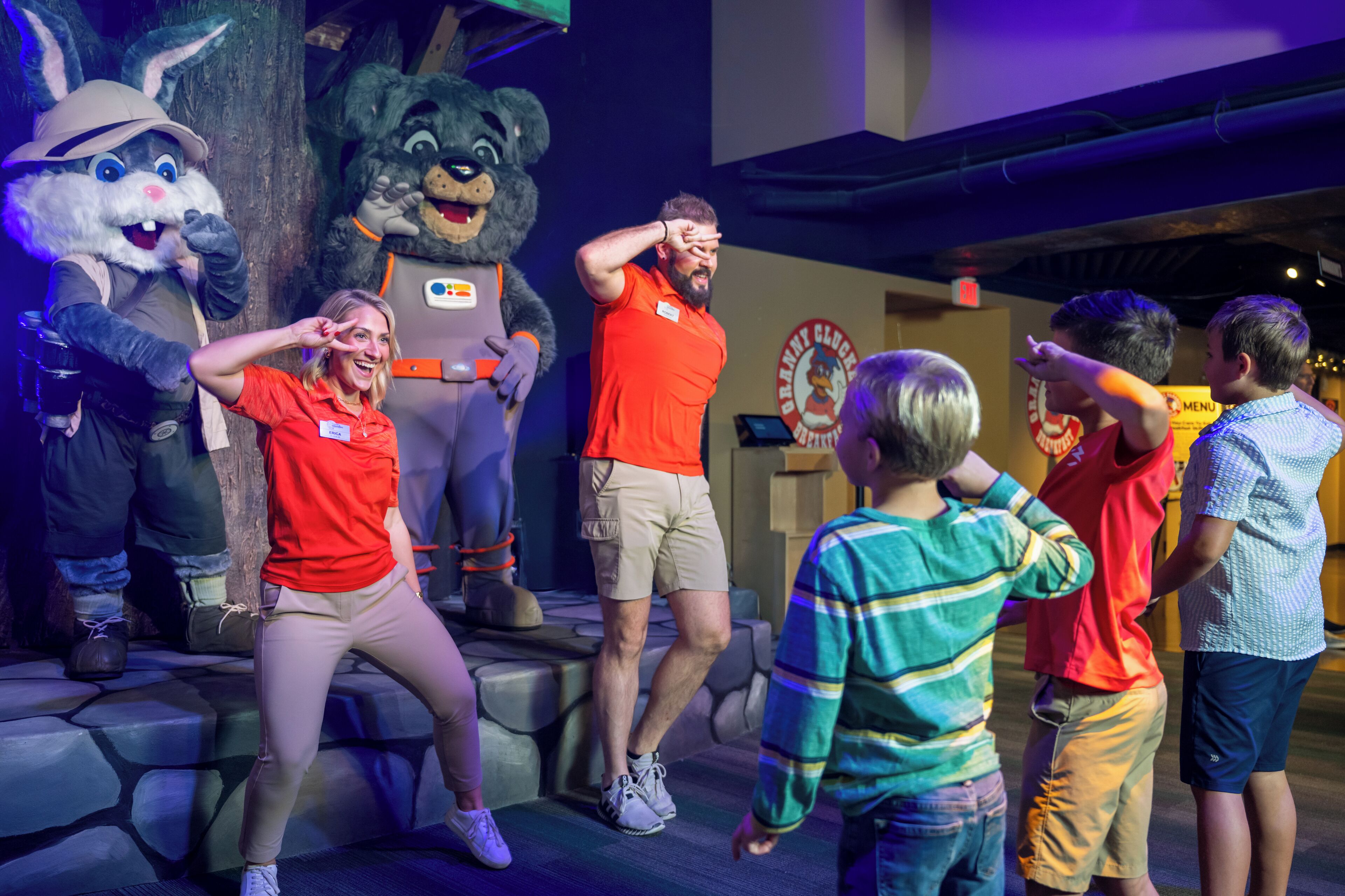 Un groupe de personnes interagissant avec des personnages animatroniques dans un décor thématique.