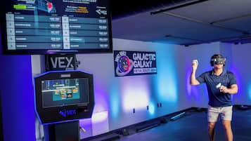 A gaming area with a leaderboard, a VEX gaming console, and a sign for "Galactic Galaxy Virtual Reality Arena".