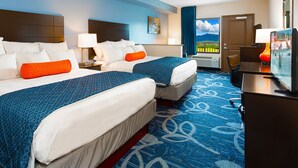 A hotel room with two beds, a desk, a TV, and a window with a view. - Country Cascades Waterpark Resort (Pigeon Forge)