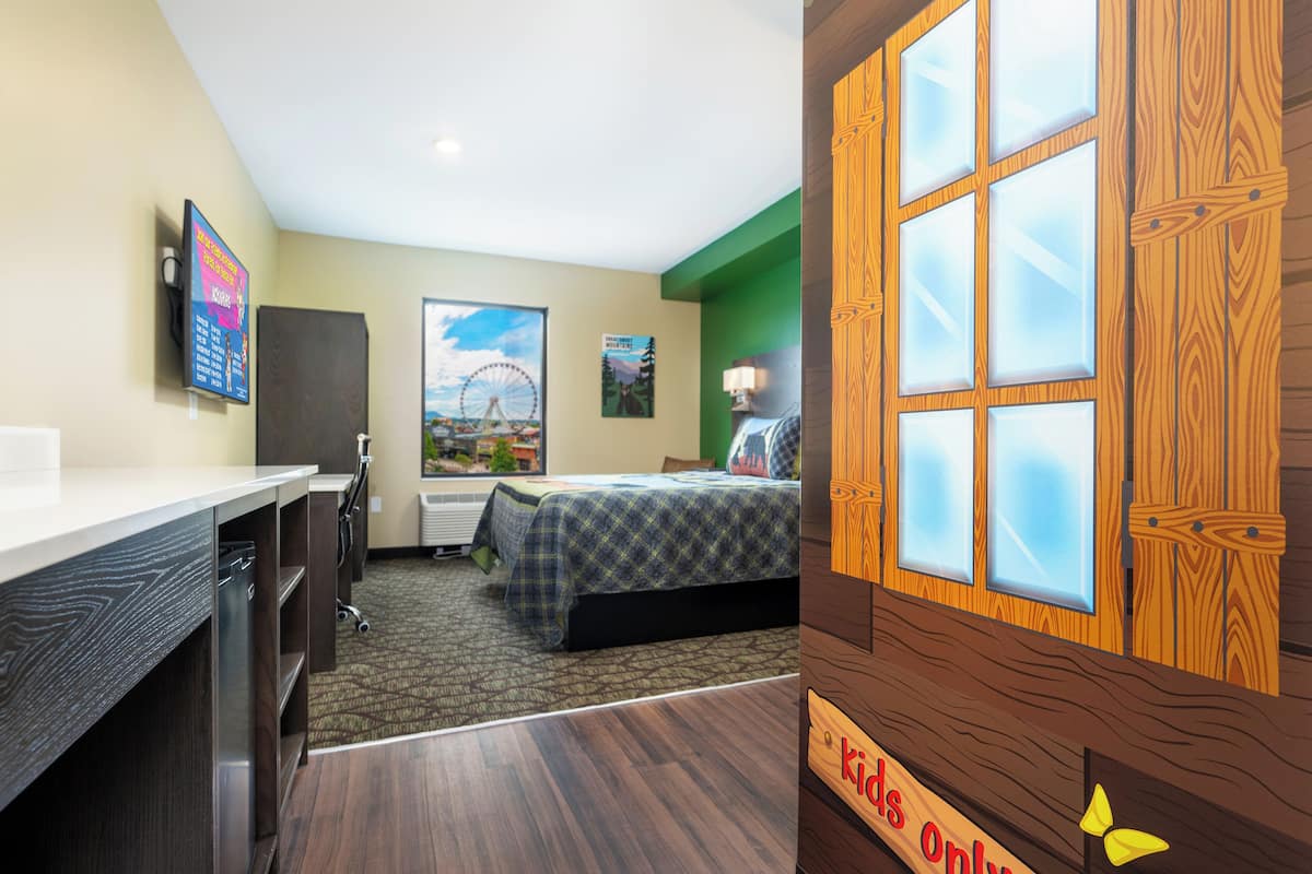 Une chambre d’hôtel avec un lit, un bureau et une vue sur une grande roue.