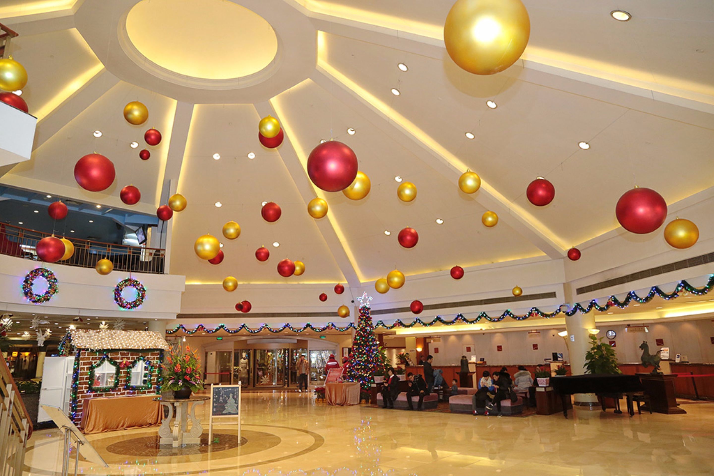 A spacious lobby with a Christmas tree, a reception desk, and a seating area.
