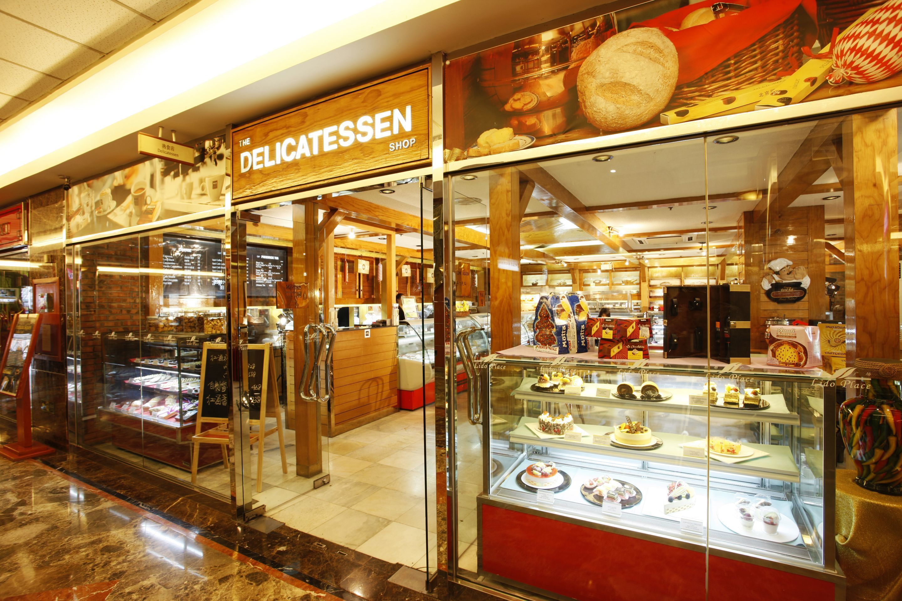 Una panadería con un escaparate de vidrio lleno de pasteles y tortas.