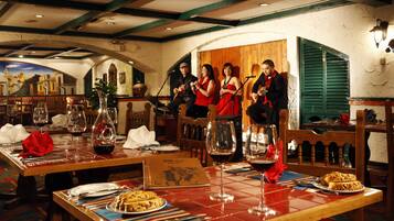 A restaurant with wooden tables, wine glasses, and a piano.