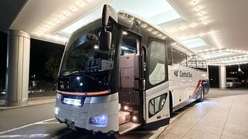 A bus with "Central Bus" written on the side parked at a bus station with a covered waiting area.