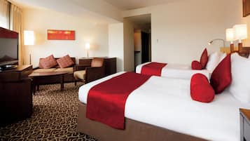 Una habitación de hotel con una cama grande, un escritorio, una silla y un televisor.