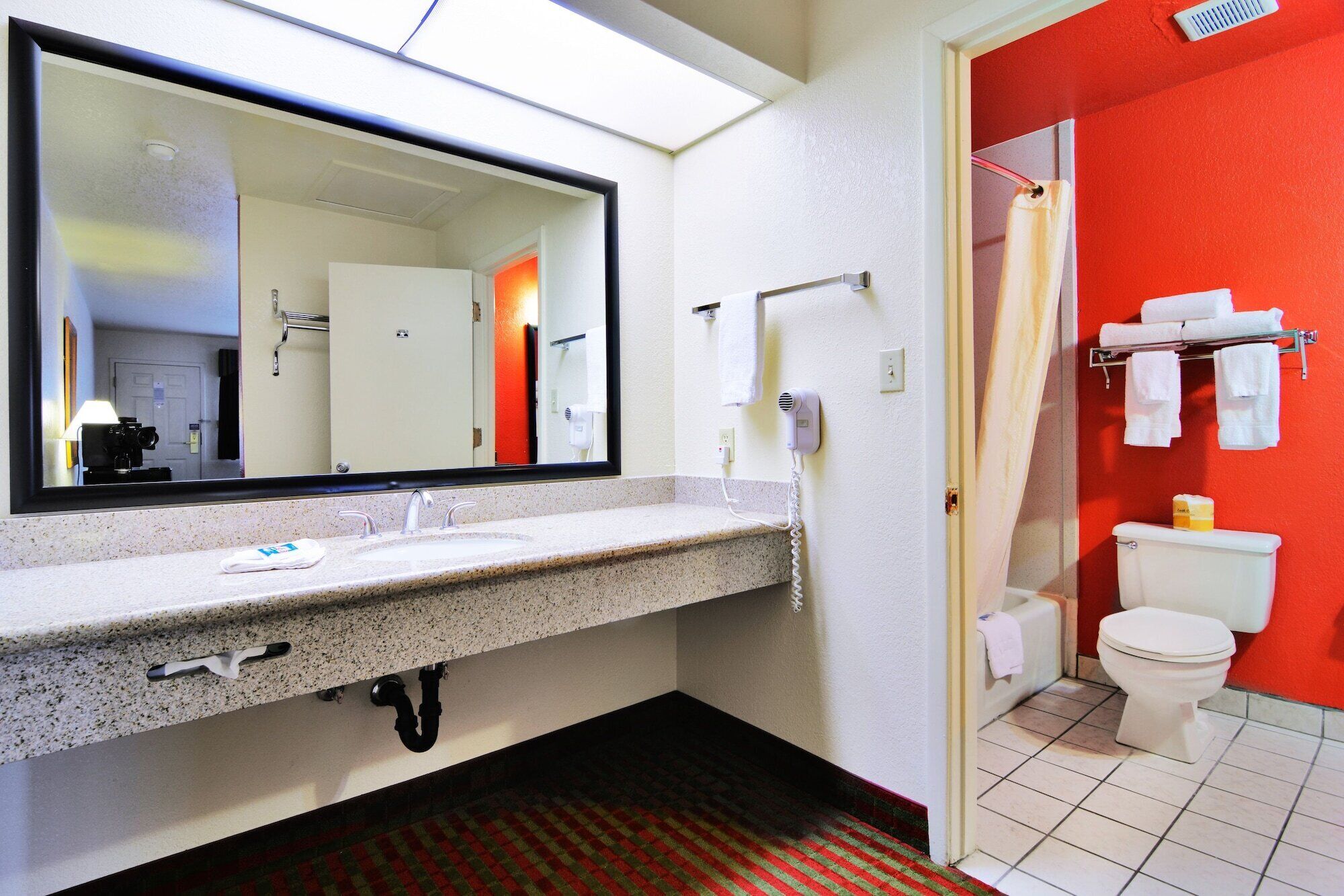 A bathroom with a sink, mirror, towel rack, and toilet.