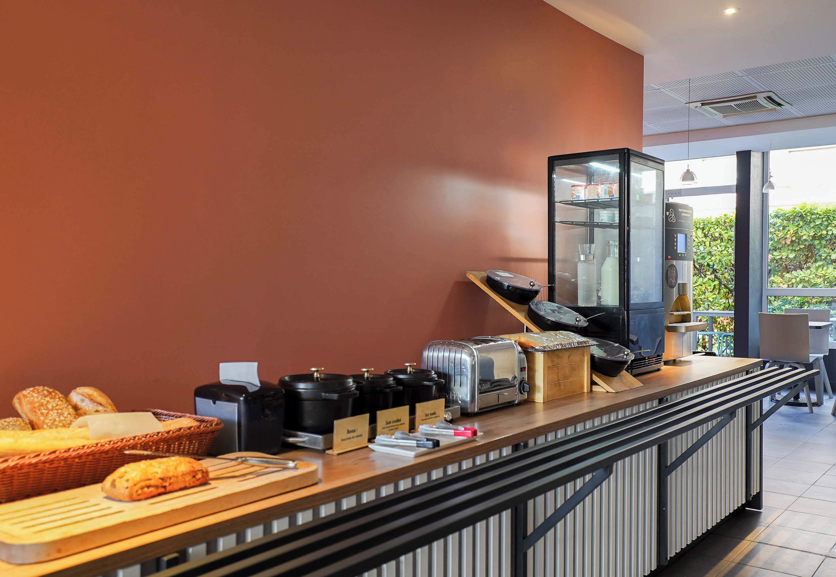 A breakfast bar with bread, coffee makers, and a water dispenser.