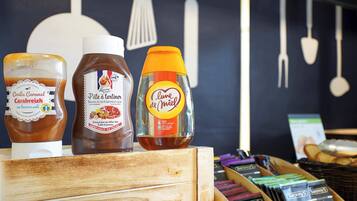 A selection of food products including jars of caramel and tartinier, and a bottle of liqueur.