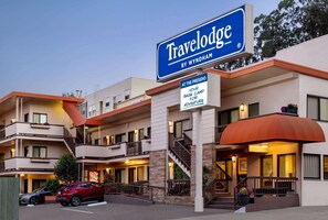 A Travelodge by Wyndham hotel with multiple balconies, a central entrance, and a parking area. - Travelodge by Wyndham Presidio San Francisco (San Francisco)
