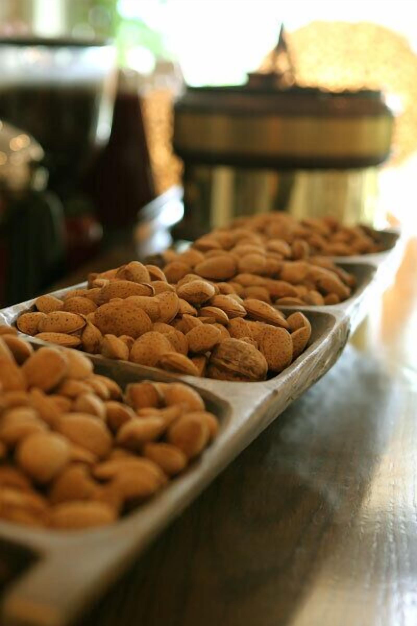 A tray of almonds on a wooden table.