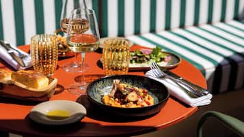 A dining table with a meal, wine glasses, and cutlery.
