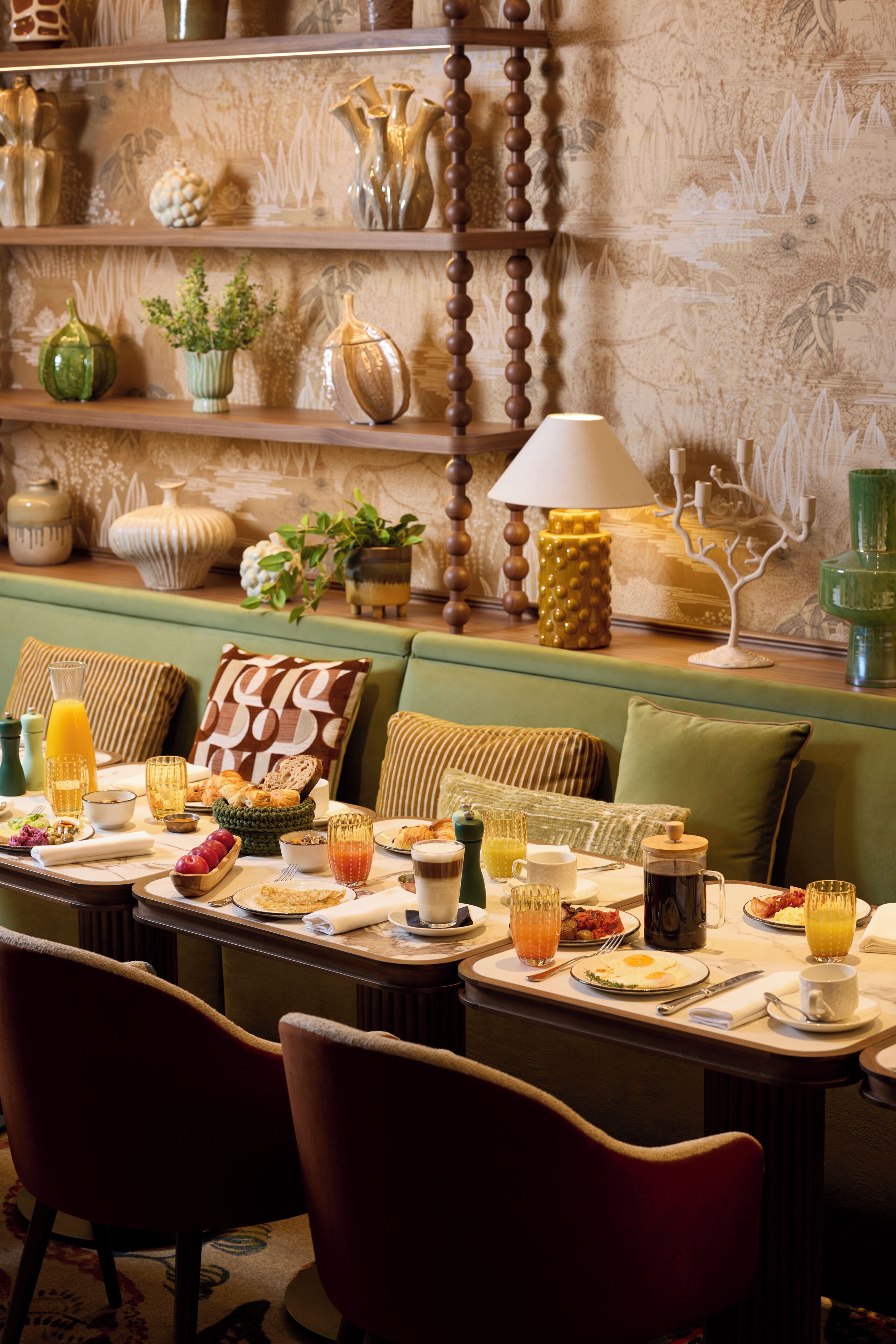 A dining area with a table set for breakfast, including plates, glasses, and a coffee pot.