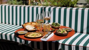 A dining table with a variety of dishes, glasses, and cutlery. - Grand Hôtel Roi René Aix - MGallery Collection (Aix-en-Provence)
