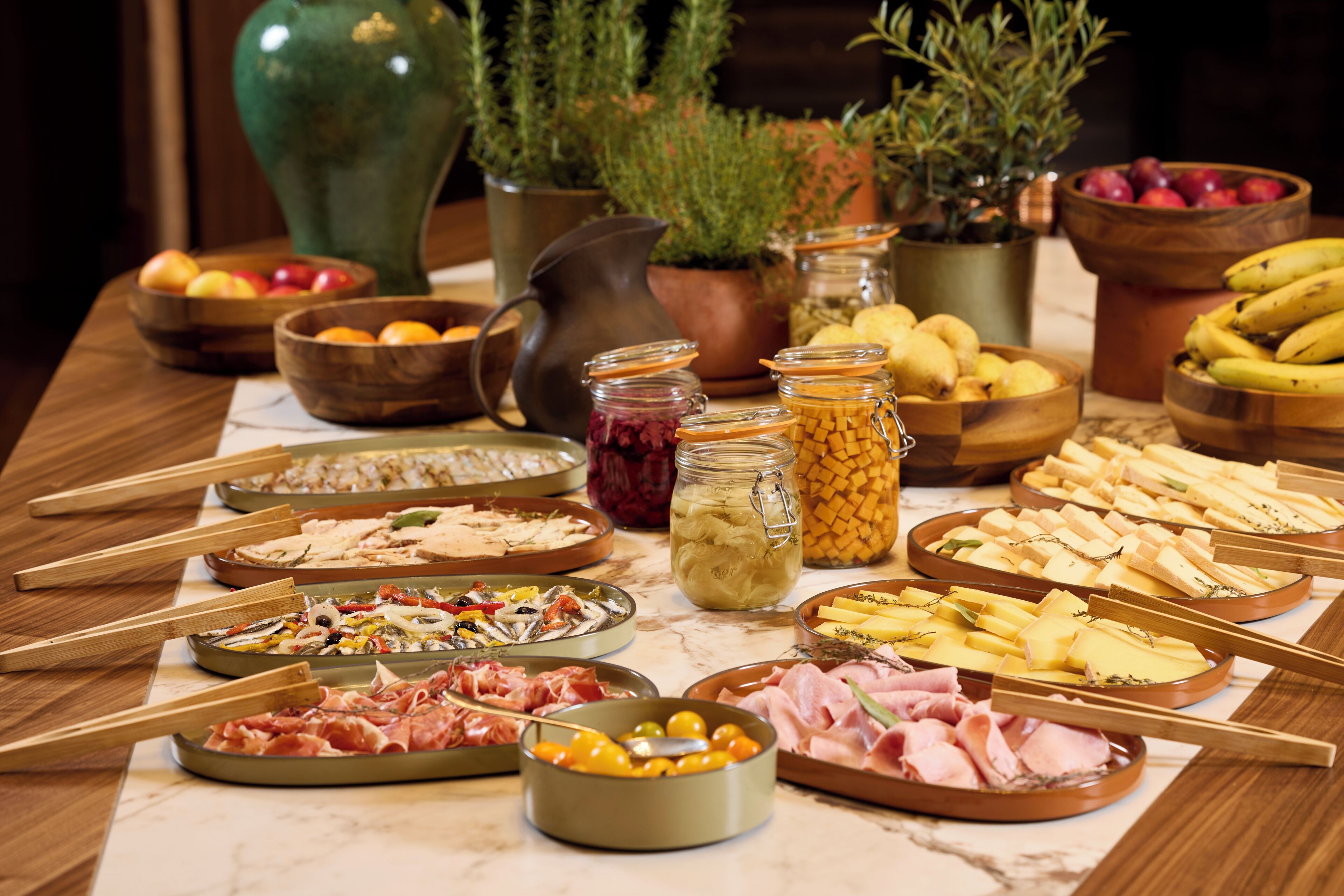 Une table sur laquelle sont disposés divers aliments et ustensiles, notamment des bols, des pots et des baguettes en bois.