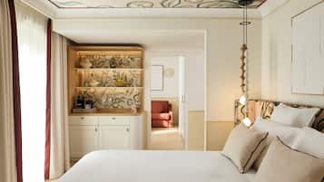 Une chambre à coucher avec un lit, une armoire, une machine à café et un canapé à l’arrière-plan.