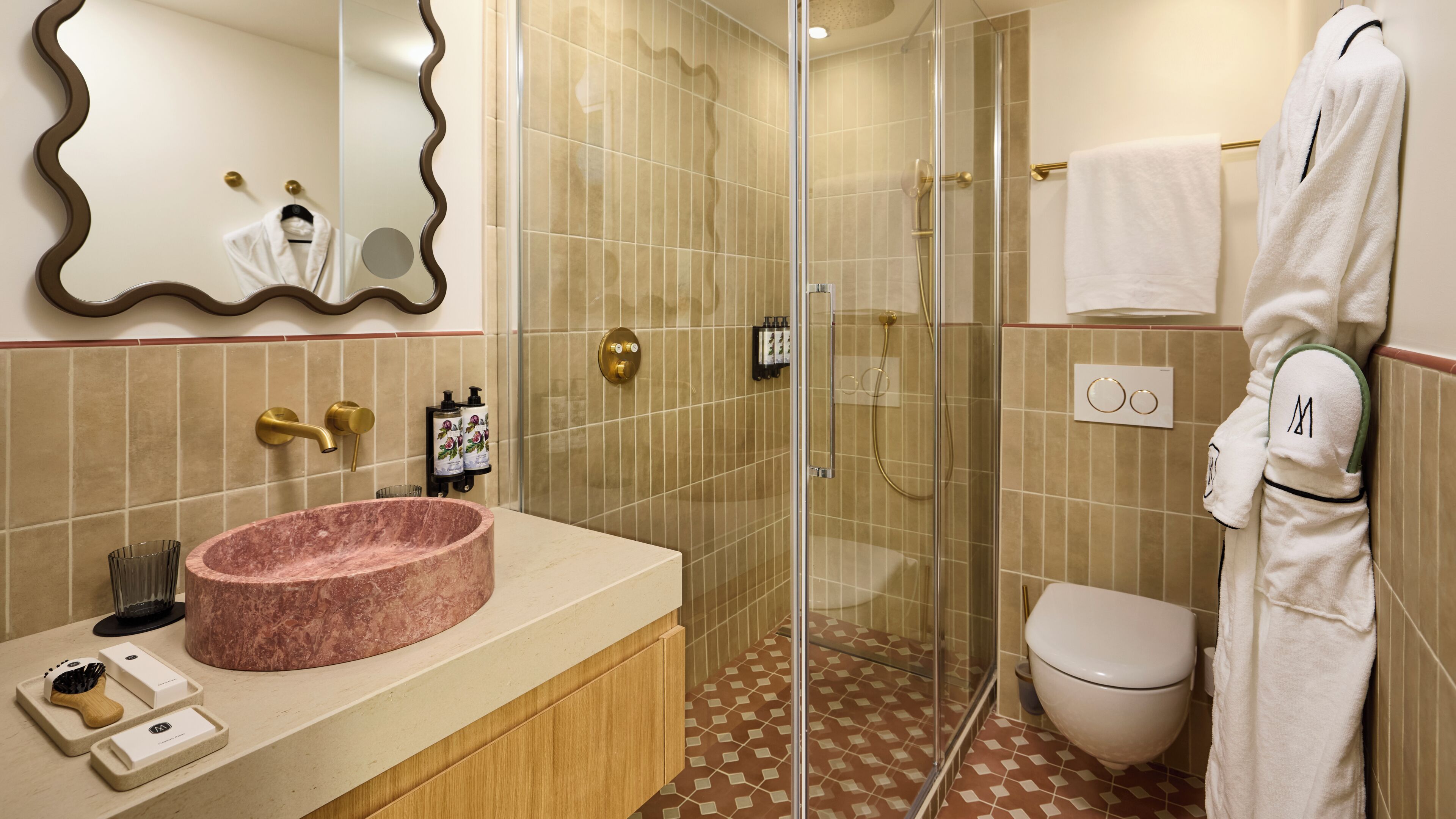 A bathroom with a marble sink, a glass-enclosed shower, a toilet, and a towel rack.