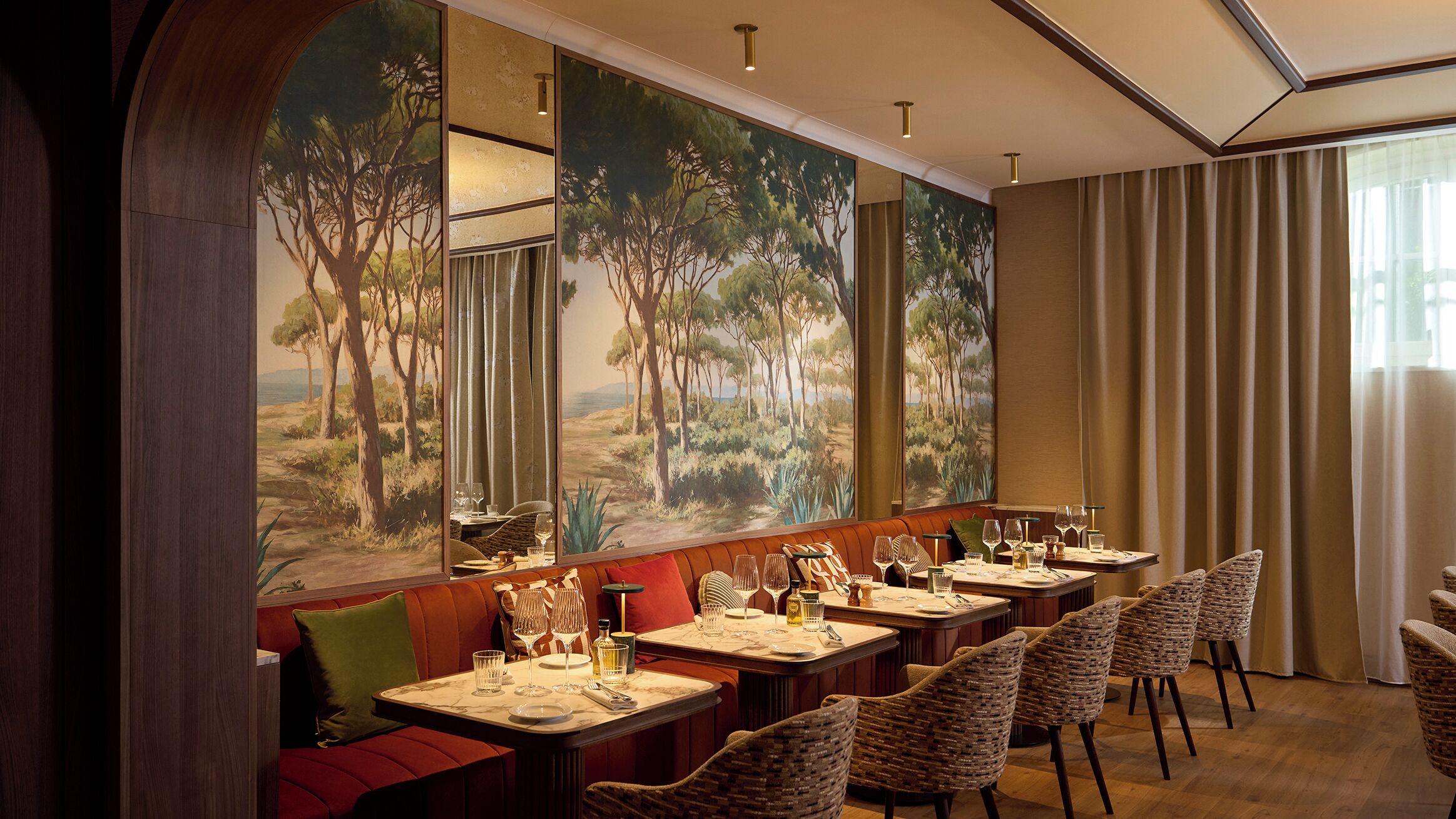 A restaurant with a long counter, multiple tables, and chairs.