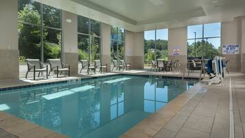 A swimming pool with lounge chairs and a lifeguard stand.