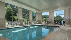 A swimming pool with chairs and tables, large windows, and safety signs. - Hampton Inn & Suites Asheville Biltmore Village (Asheville)