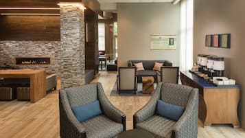 A lobby with a fireplace, seating area, and a reception desk.